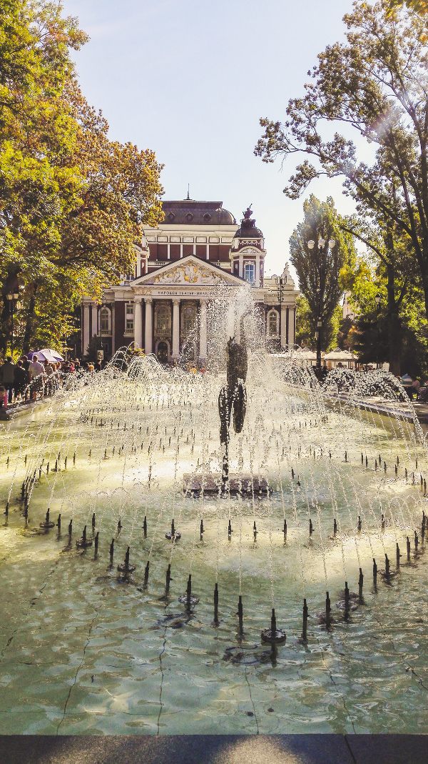 Ivan Vazov National Theatre and the City Garden with the Fountain in front of it in Sofia. Discover the best things to see in Sofia Bulgaria from this insider's guide to Sofia. #sofia #sofiaguide #sofiatravelguide #sofiabulgaria #bulgaria