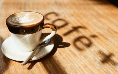 Cup of black coffee on a wooden table in natural morning light, representing drinking coffee on an empty stomach and its effects on the body