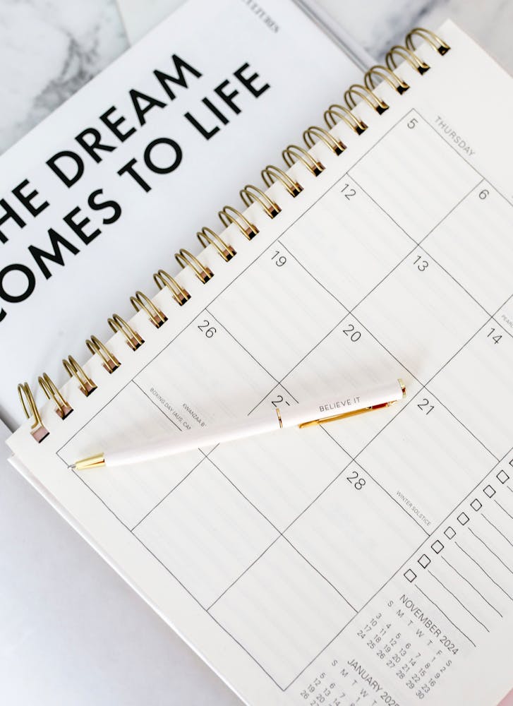 Planner and calendar with pen representing an intentional reset and clearing mental blocks before the new year