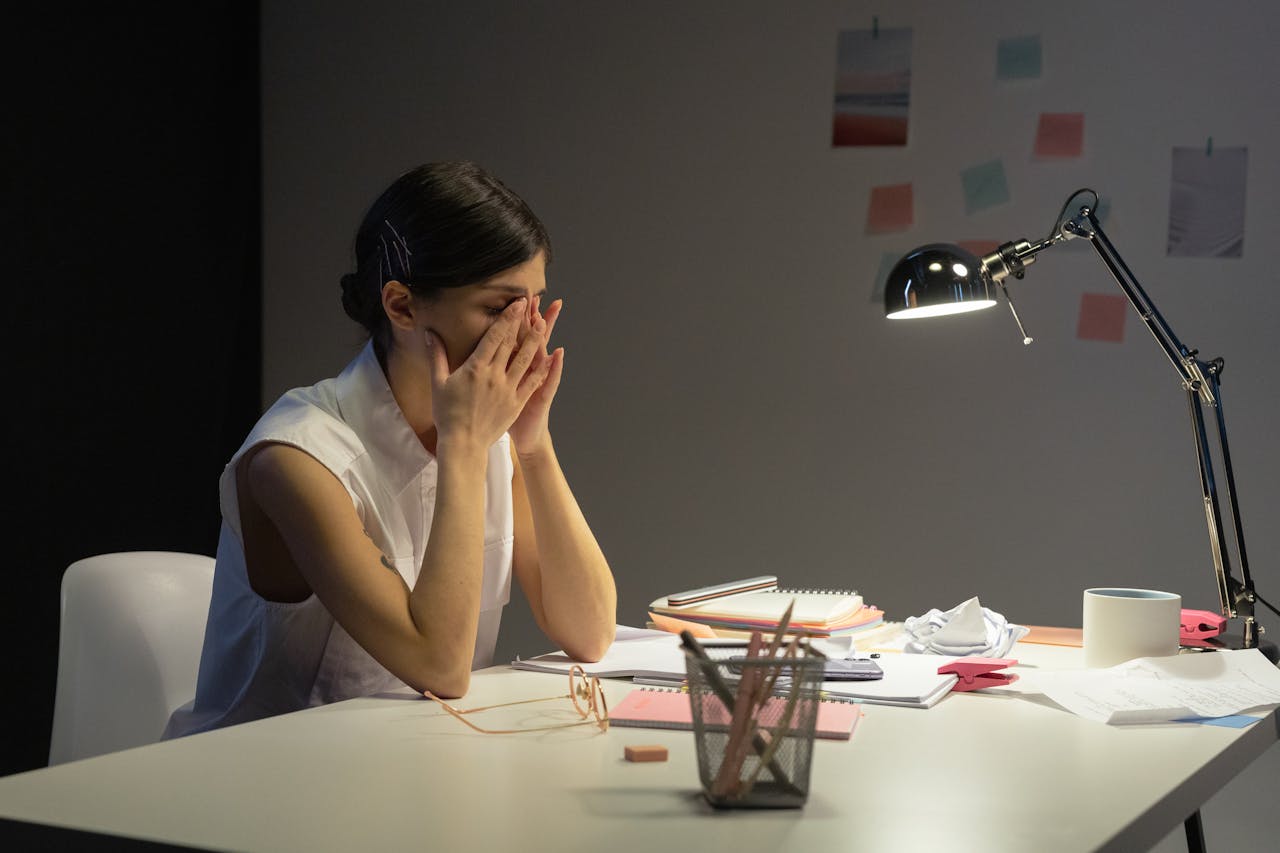 Person experiencing mental exhaustion and emotional pressure while working at a desk