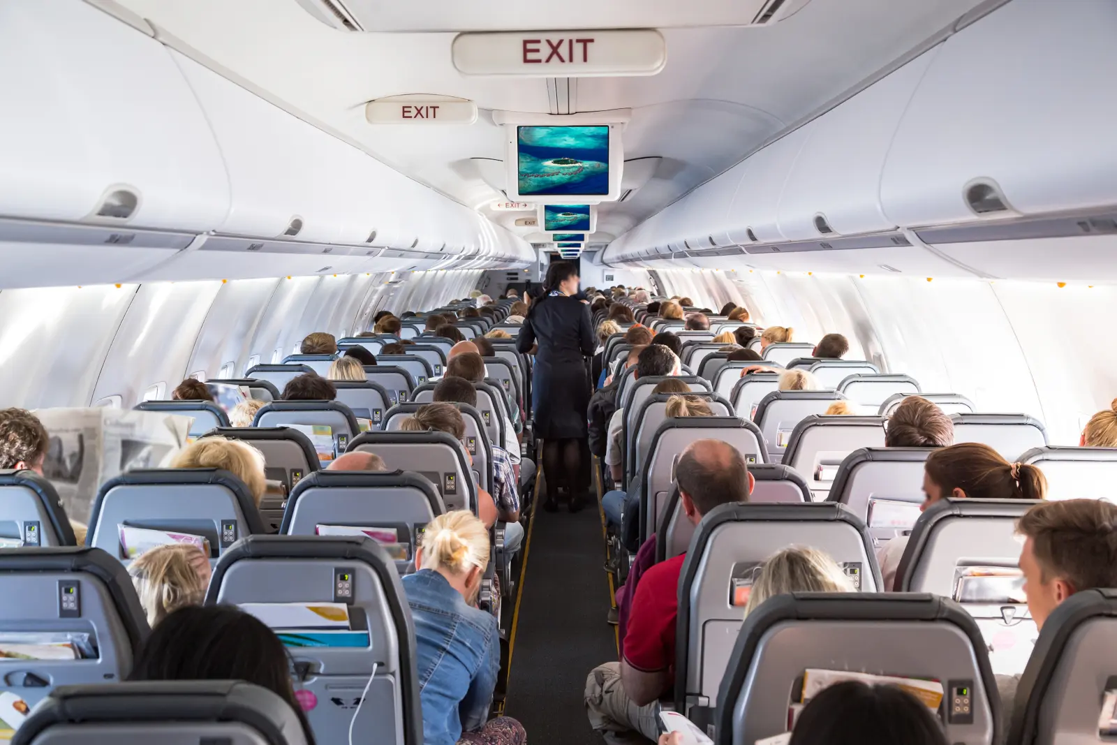 Passengers seated close together inside an airplane cabin, showing why personal grooming on a plane affects everyone nearby