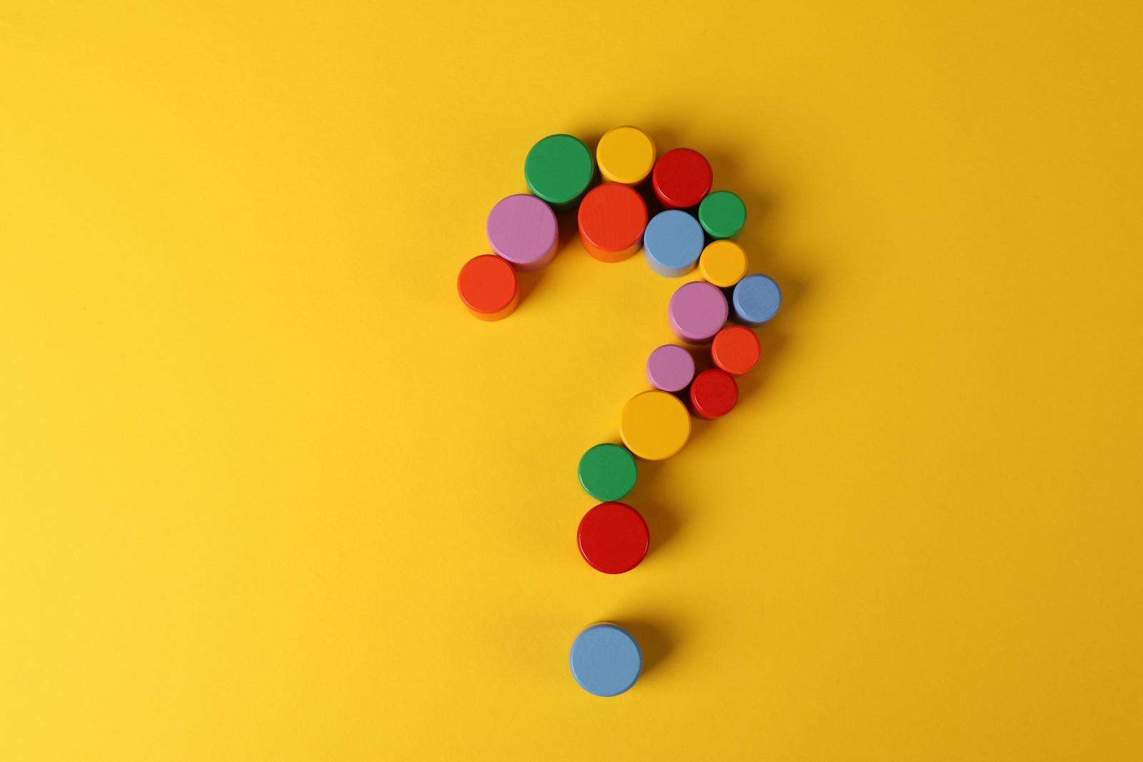 Colorful question mark on yellow background for travel brain teasers