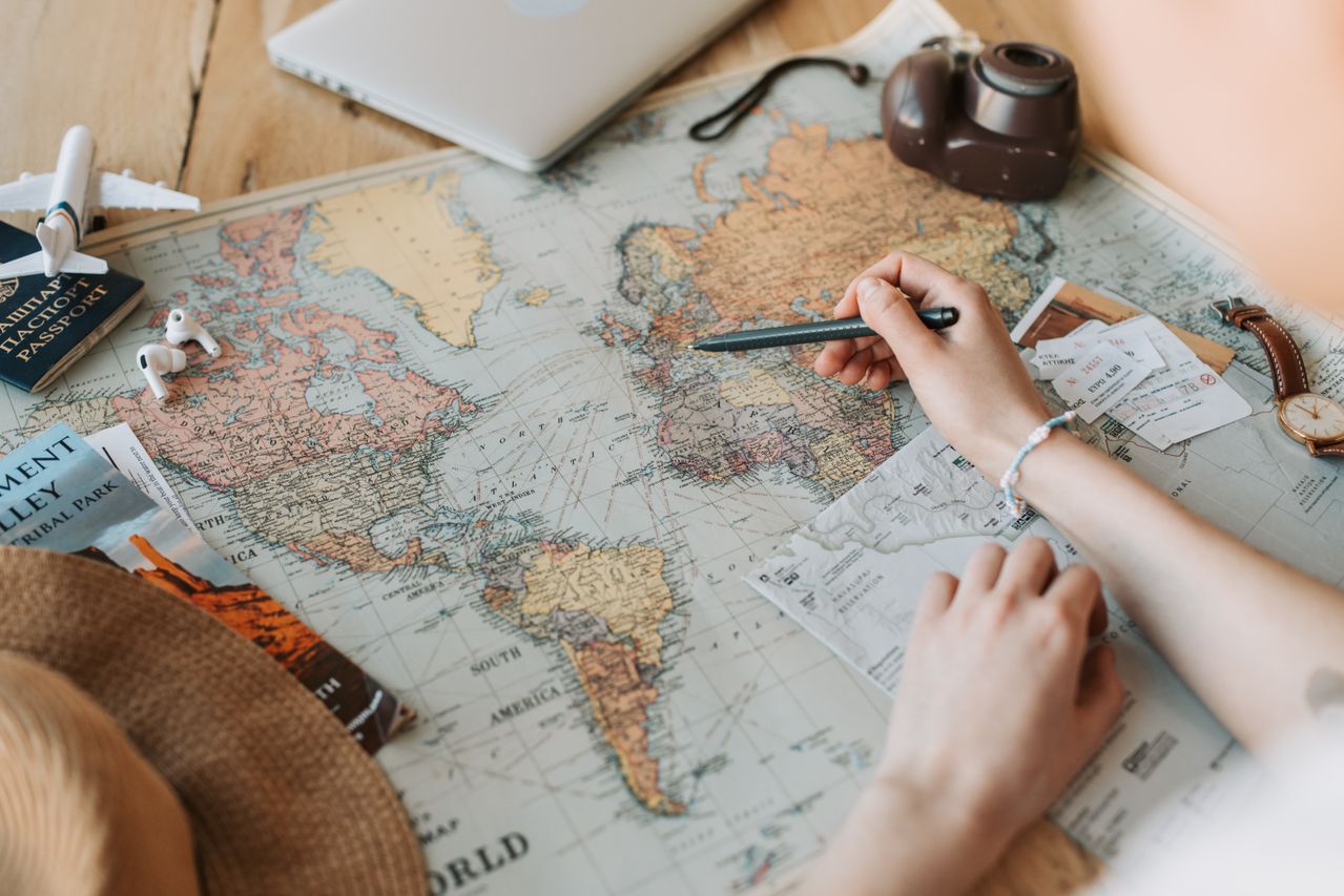 AI travel planning with map, passport, tickets, laptop, and camera for building a realistic trip itinerary