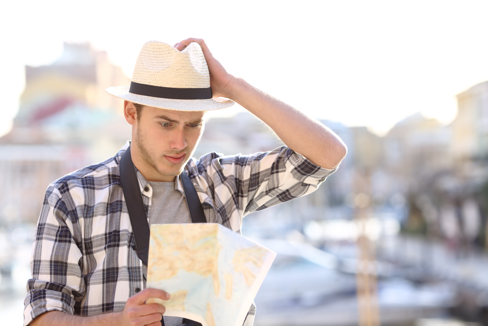 Confused tourist looking at a city map while trying to find the right travel destination
