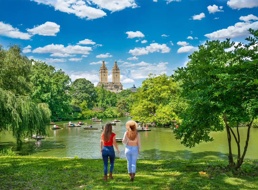 Friends walking in Central Park by the lake for a free staycation idea