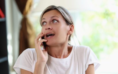 Woman looking uncomfortable while receiving unsolicited advice during a phone conversation
