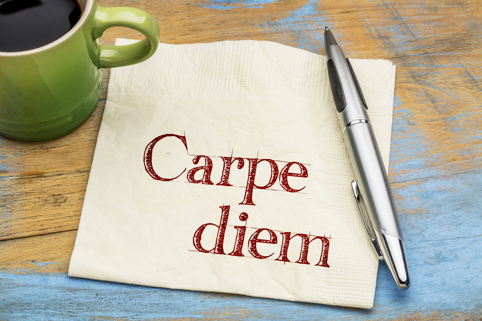 Carpe Diem Latin phrase written on a napkin next to coffee, one of the famous Latin proverbs and sayings still used today