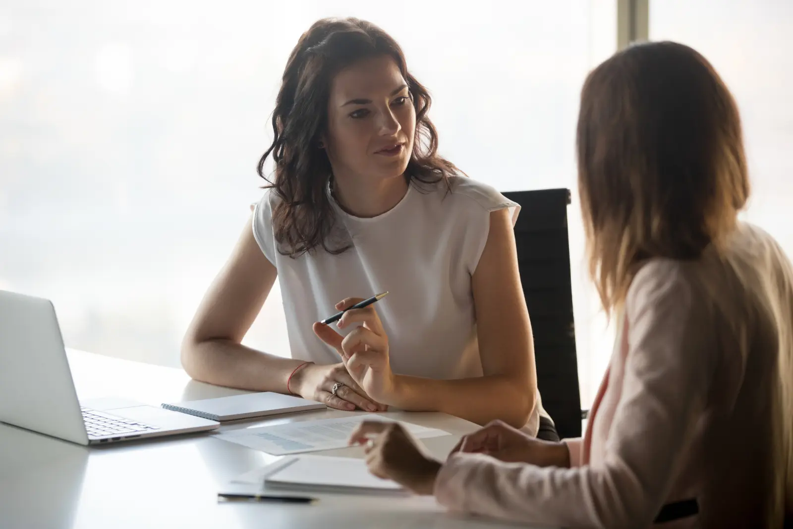 Two colleagues having a focused conversation in an office