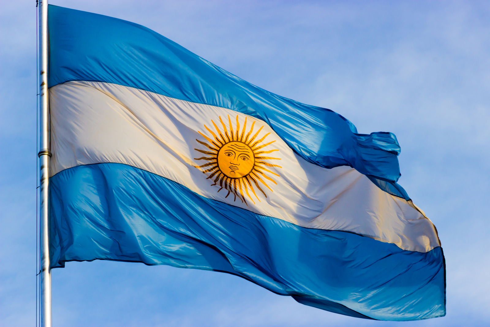 Argentine flag with the Sun of May waving against the sky for 100 Argentina facts