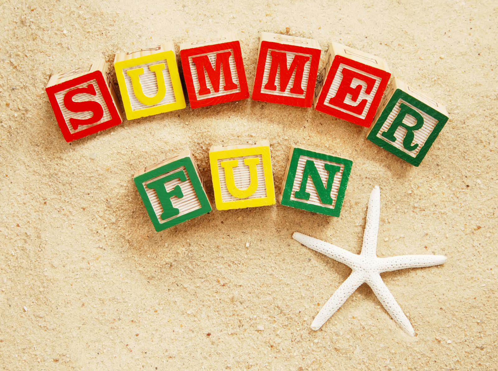 Summer Fun written with colorful blocks on sand beside a starfish for an article with 200 Fun Summer Trivia Questions and Answers (Easy to Hard)