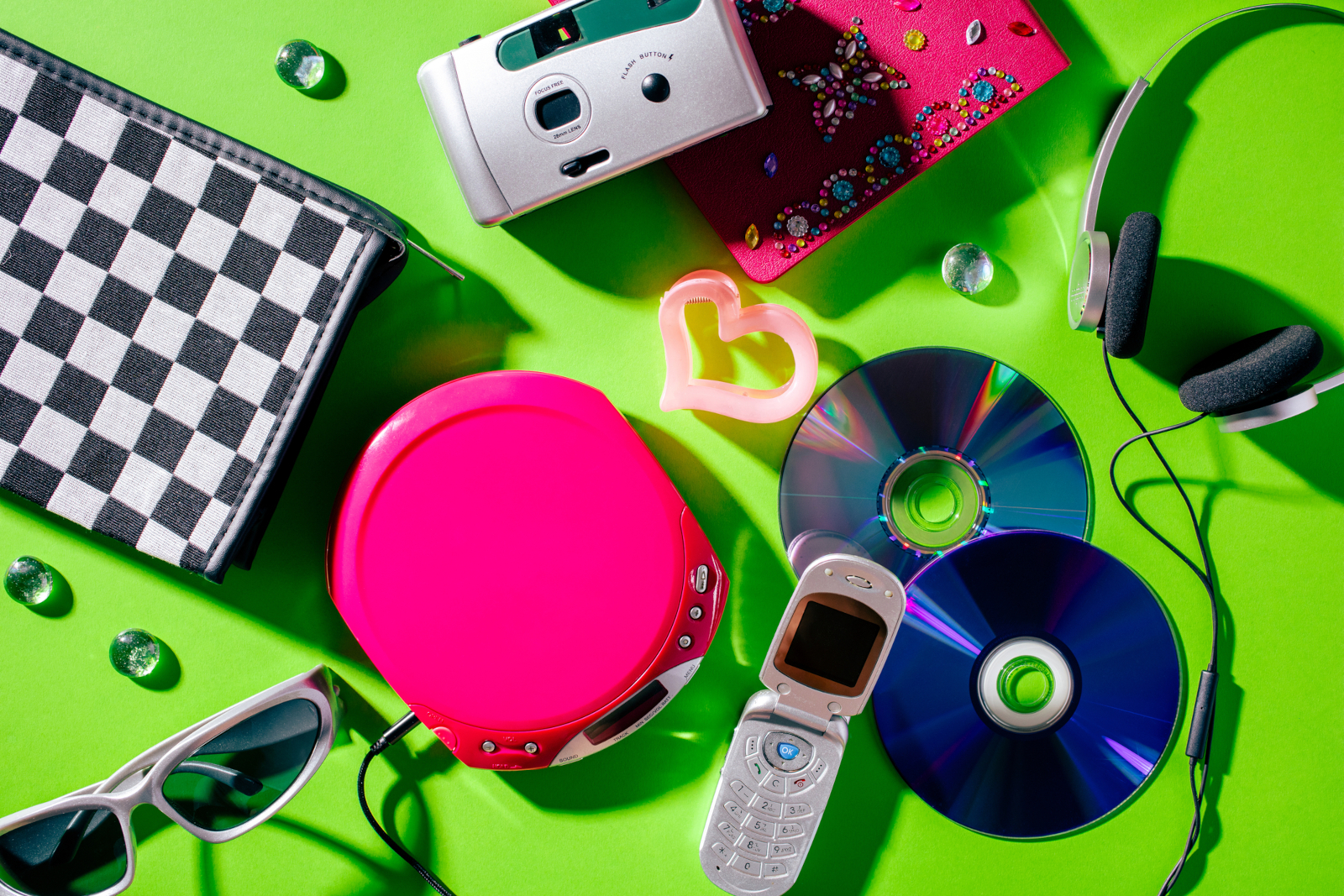 2000s technology with a flip phone CDs portable CD player camera and headphones