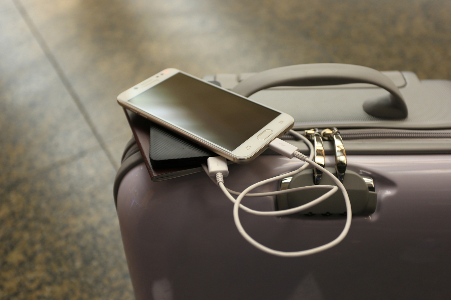 Power bank charging a smartphone at an airport before a flight