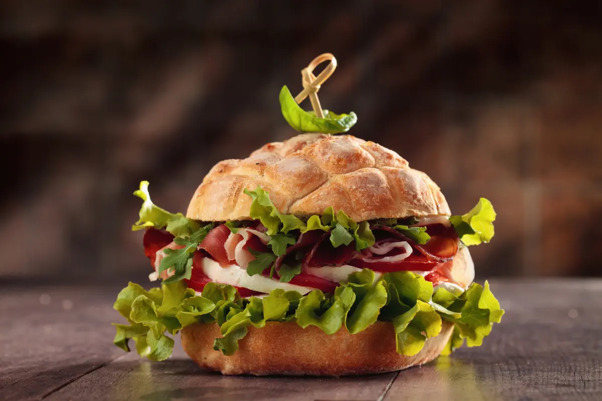 image of a burger with meat, salad, tomatoes