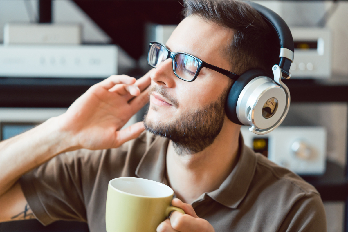 Man enjoying music at home while drinking coffee