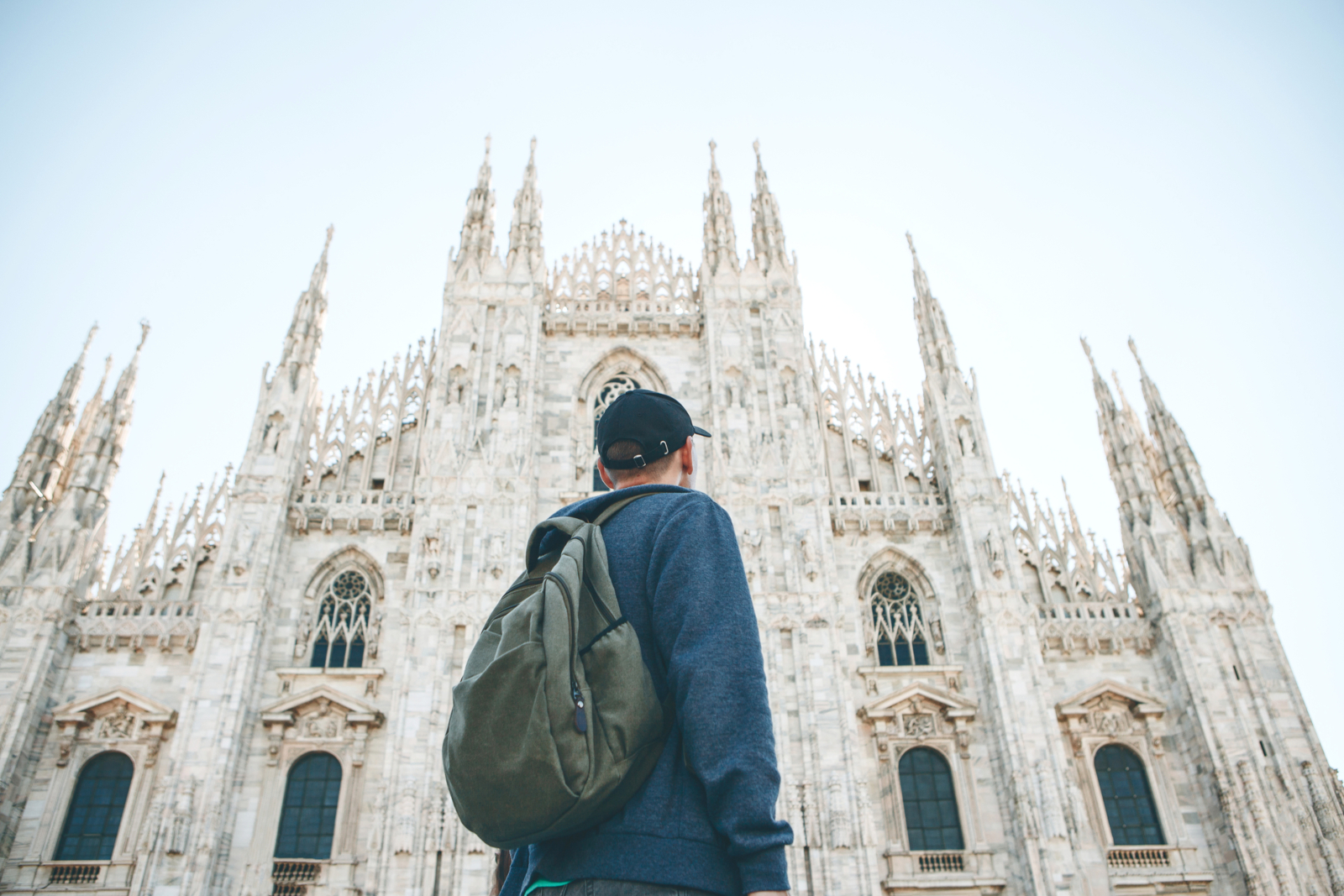 Male tourist looking at the Duomo Cathedral in Milan Italy