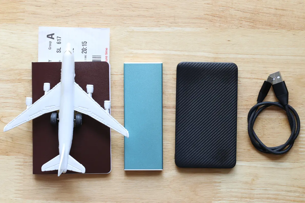 Power bank with a smartphone, passport and travel items before a flight