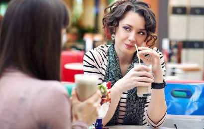 Two women talking over drinks during lunch