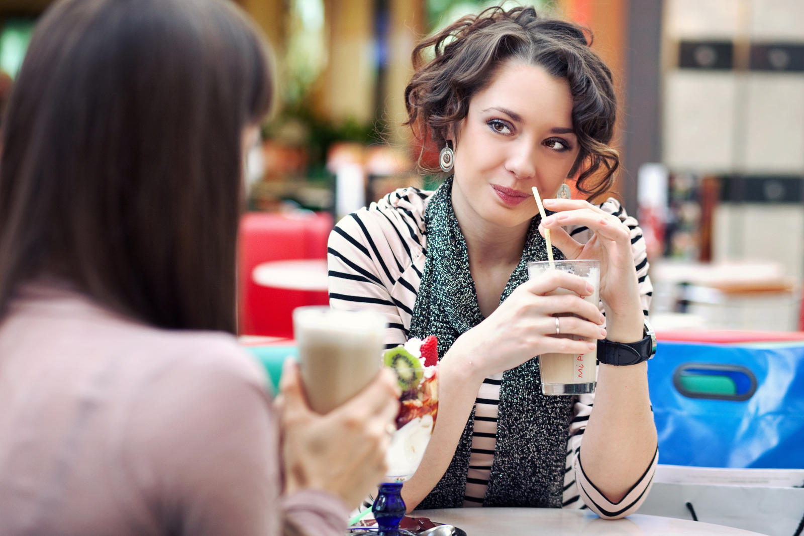 Two women talking over drinks during lunch
