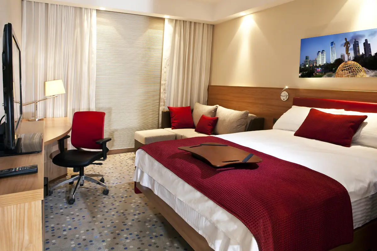 Modern hotel room with double bed, desk and seating area