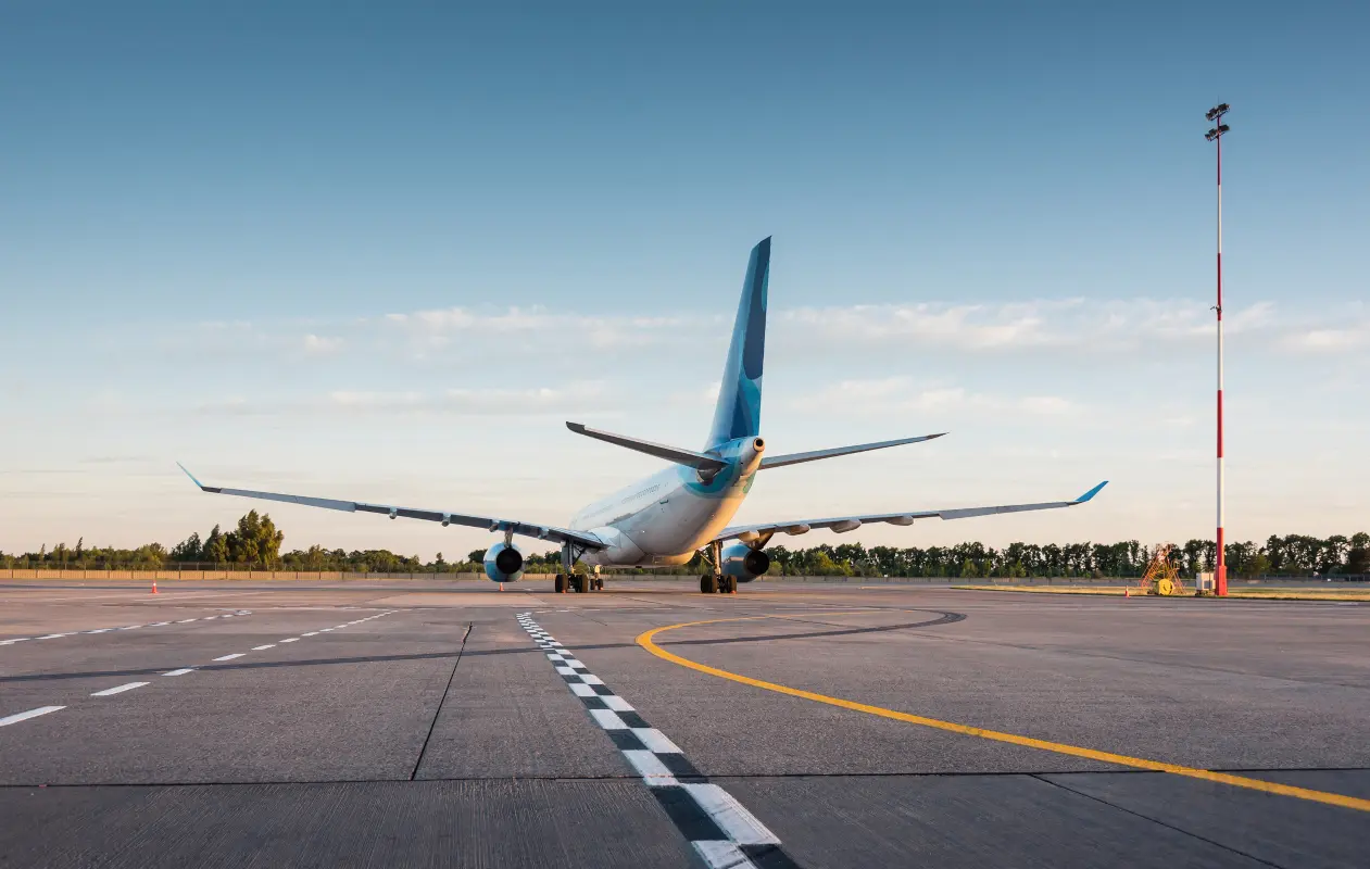 Passenger airplane standing on a marked airport apron at sunset