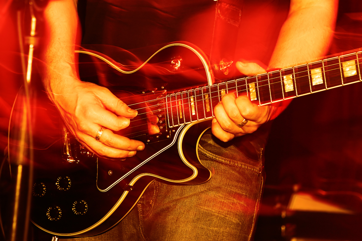 Musician playing guitar during a live concert