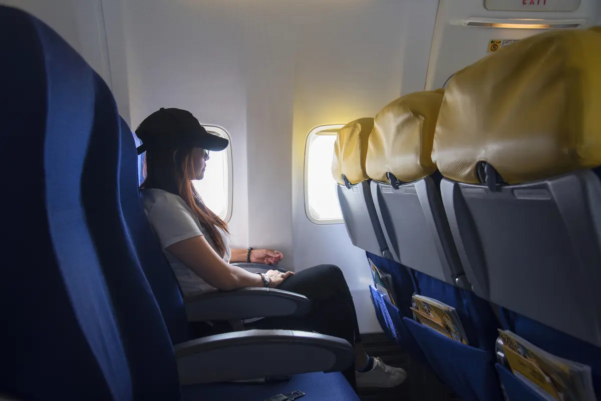Passenger sitting beside an airplane window during a flight