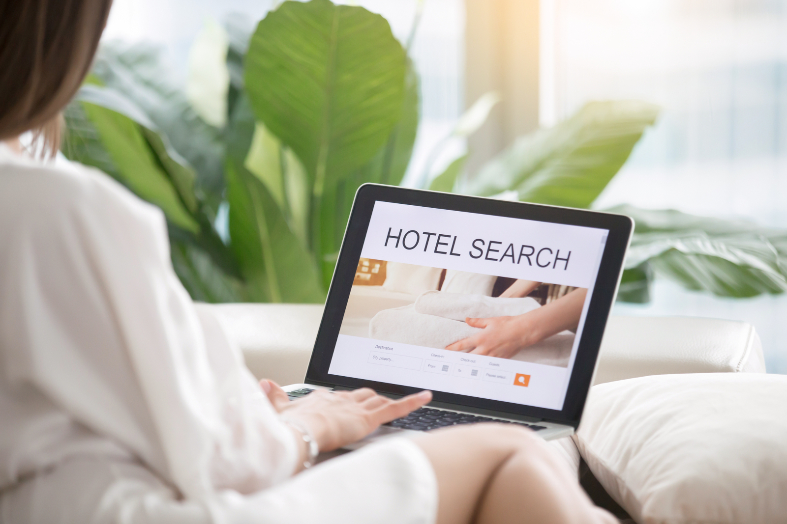 Woman checking hotels online before booking a hotel room to avoid hotel room booking mistakes