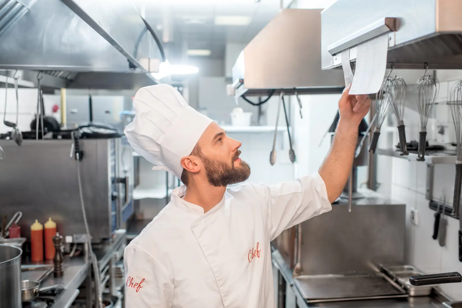 Chef checking a customer’s order ticket in a restaurant kitchen