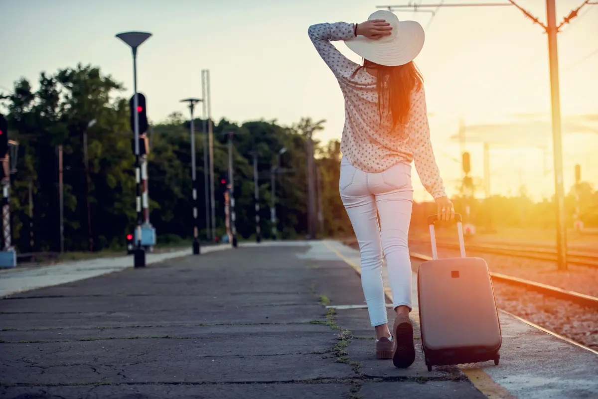Woman traveling with luggage at a train station in Europe
