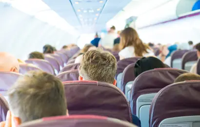Passengers getting seated inside a crowded airplane cabin