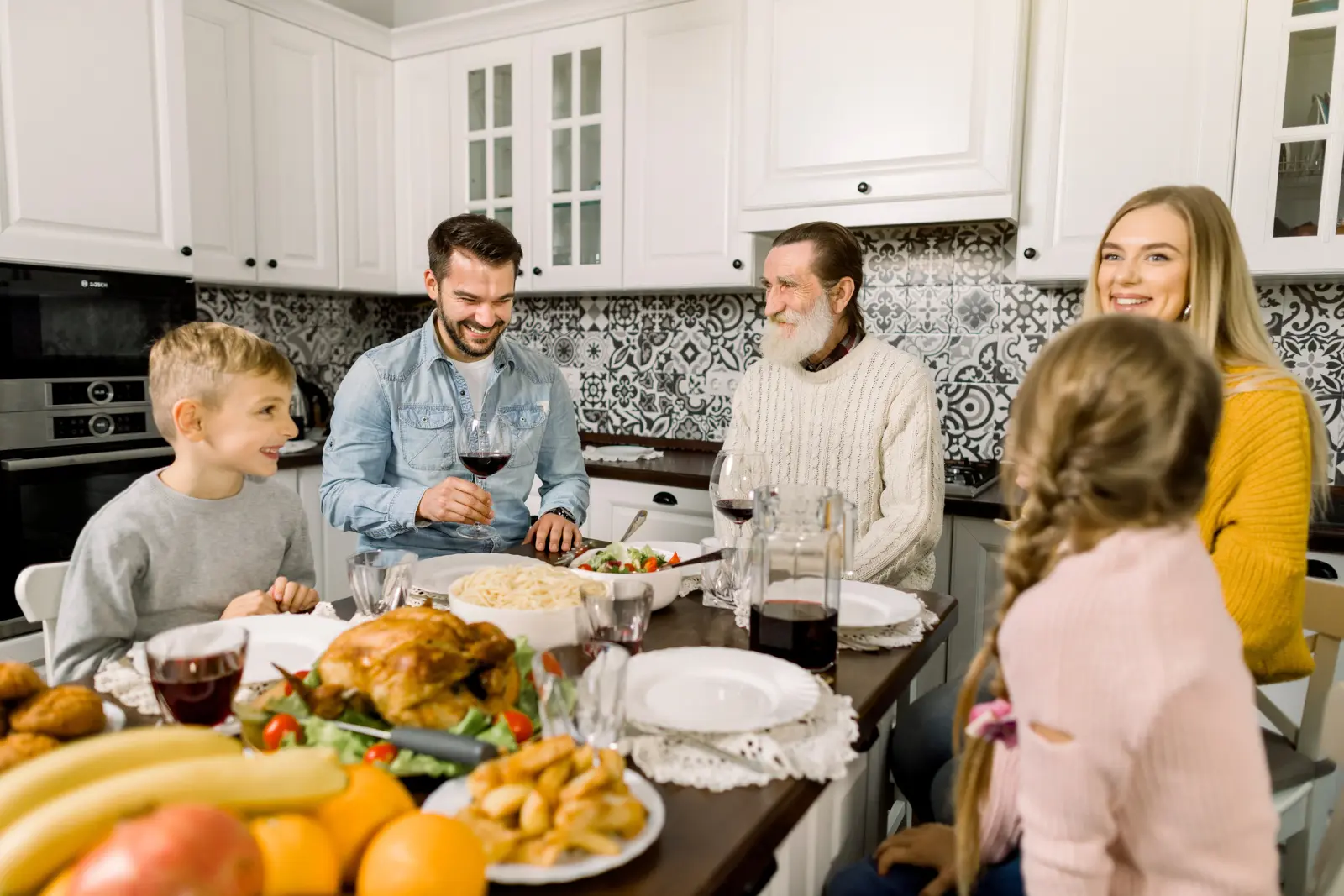 Family talking and smiling around the table during Thanksgiving dinner