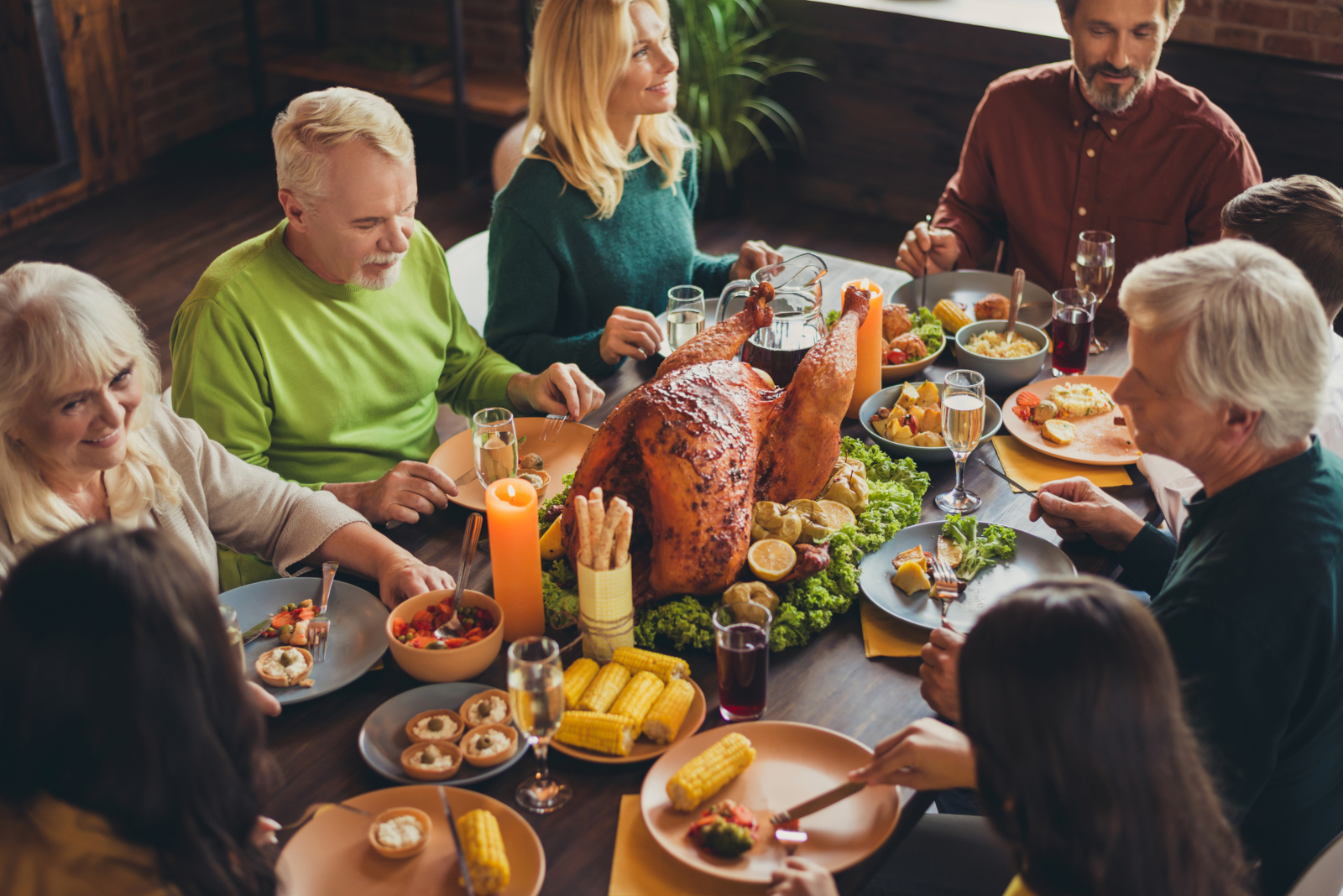 Family talking around the table during Thanksgiving dinner for an article with 100 Thanksgiving Conversation Starters for Family and Friends - Beyond “What Are You Thankful For?”