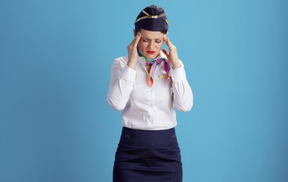 Stressed flight attendant in uniform looking overwhelmed