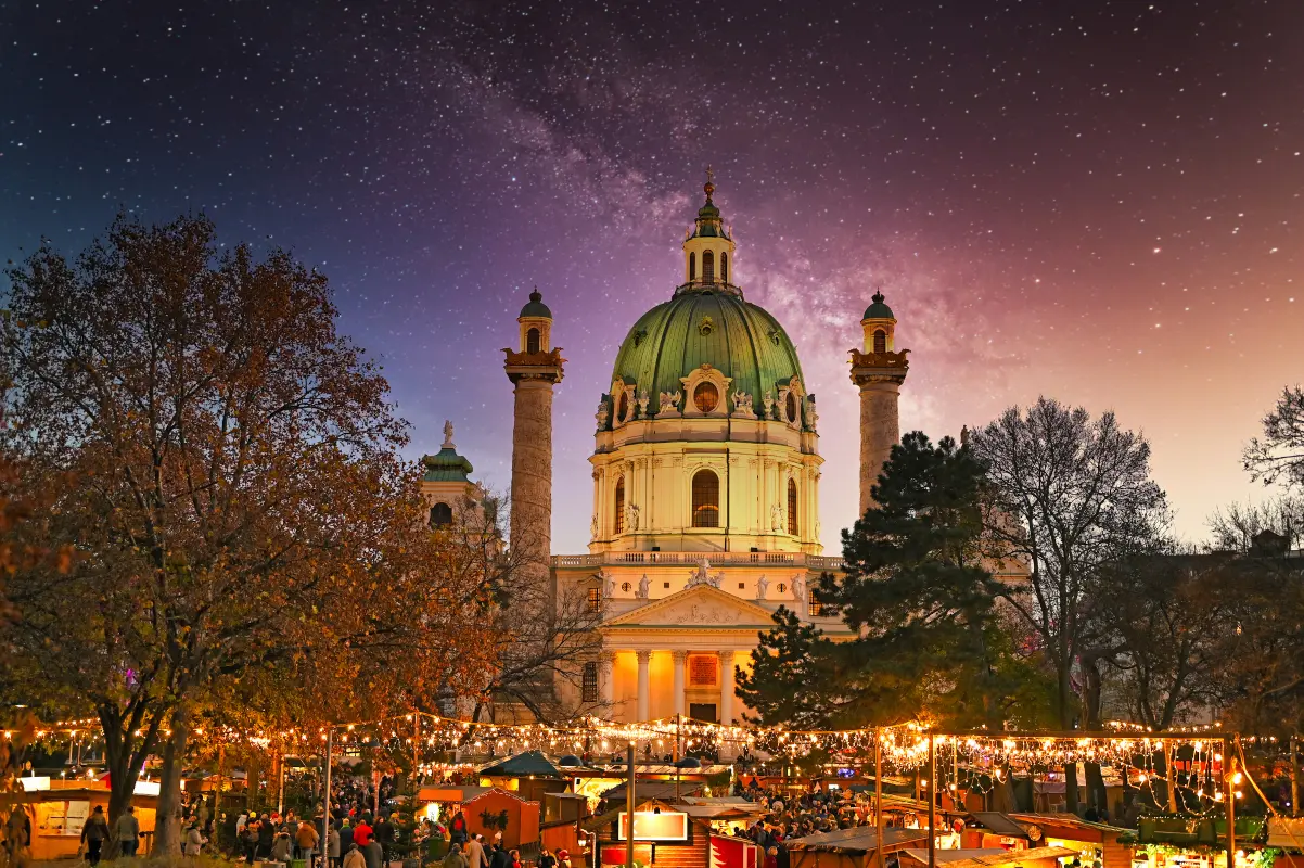 Karlsplatz Christmas market in Vienna illuminated at night with Karlskirche in the background