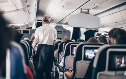 Flight attendant serving passengers inside an airplane cabin