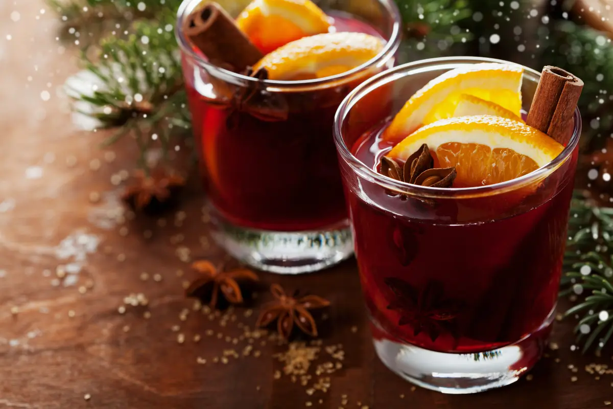 Christmas mulled wine with orange slices and warming spices on a rustic table