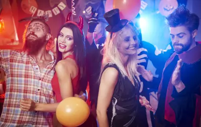 Friends in costumes having fun at a Halloween party